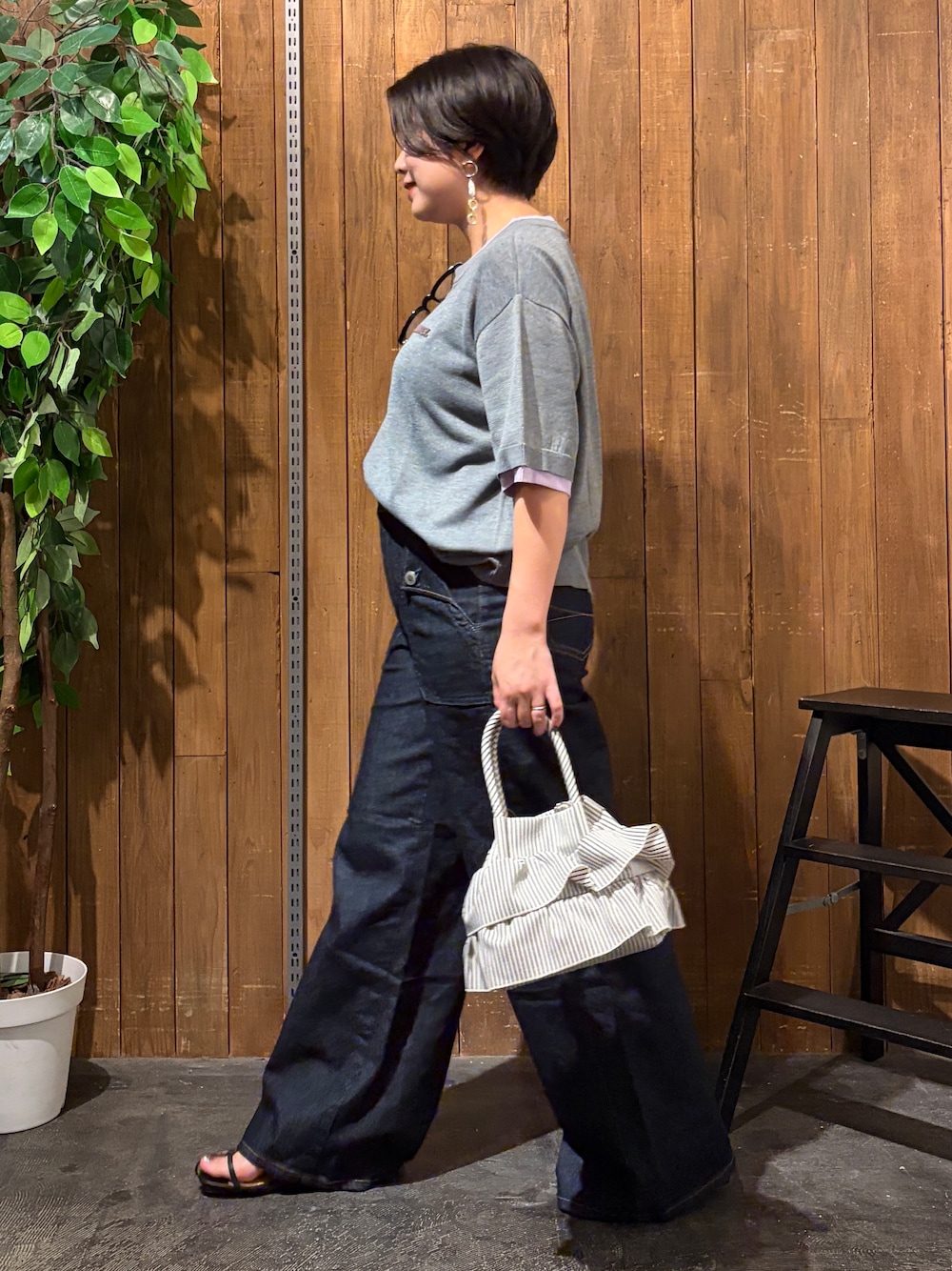ブルー系のその他パンツ、グレー系のニット/セーター、ホワイト系のショルダーバッグを着用したレディースの夏コーディネートの2枚目の写真