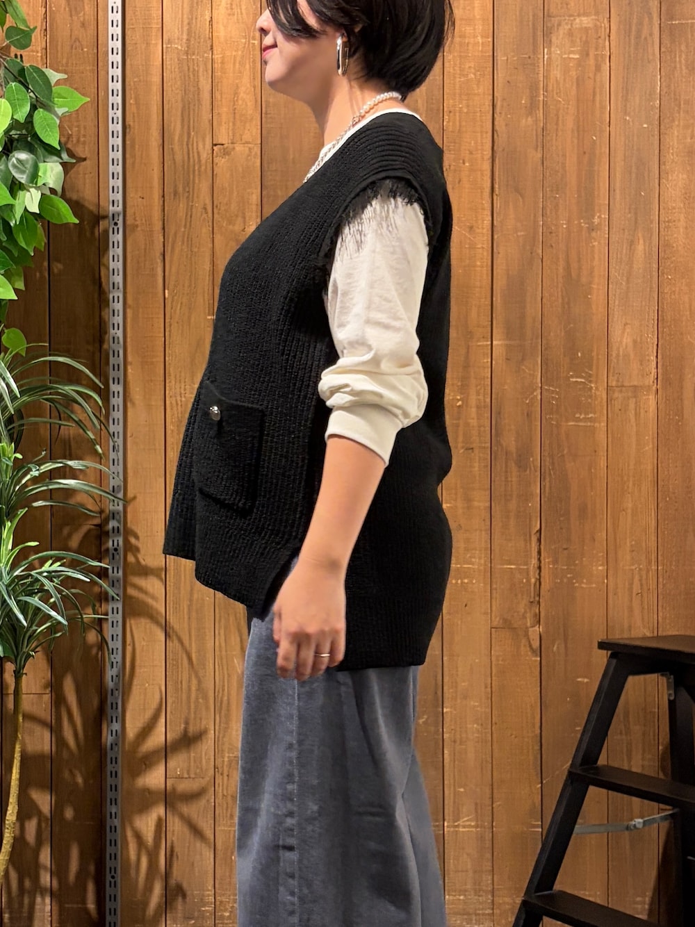 ブラック系のデニムパンツ、ホワイト系のTシャツ/カットソー、ブラック系のベストを着用したレディースの秋コーディネートの6枚目の写真