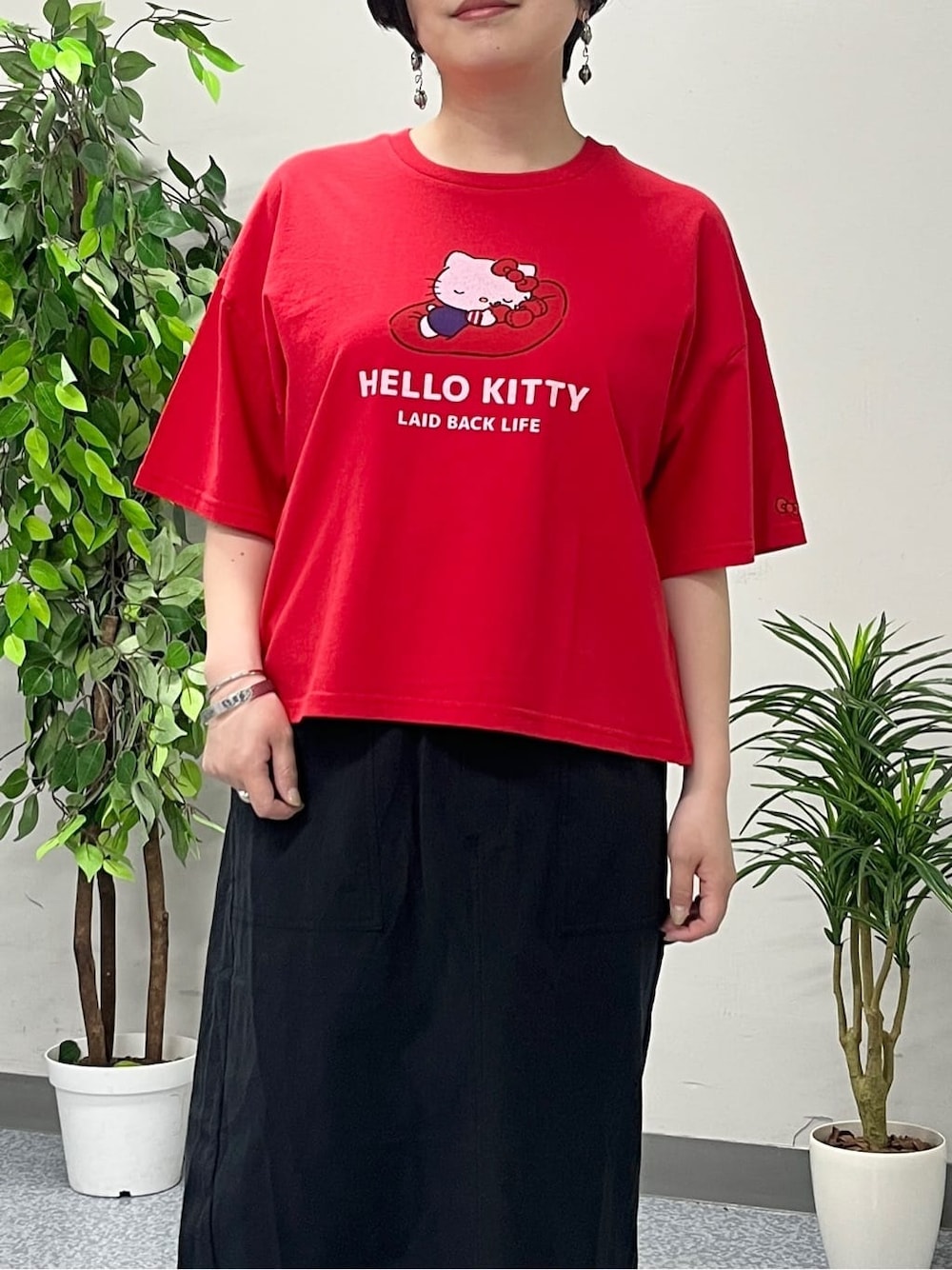 レッド系のTシャツ/カットソー、ブラック系のスカート、ブラック系のショルダーバッグを着用したレディースの春コーディネートの4枚目の写真