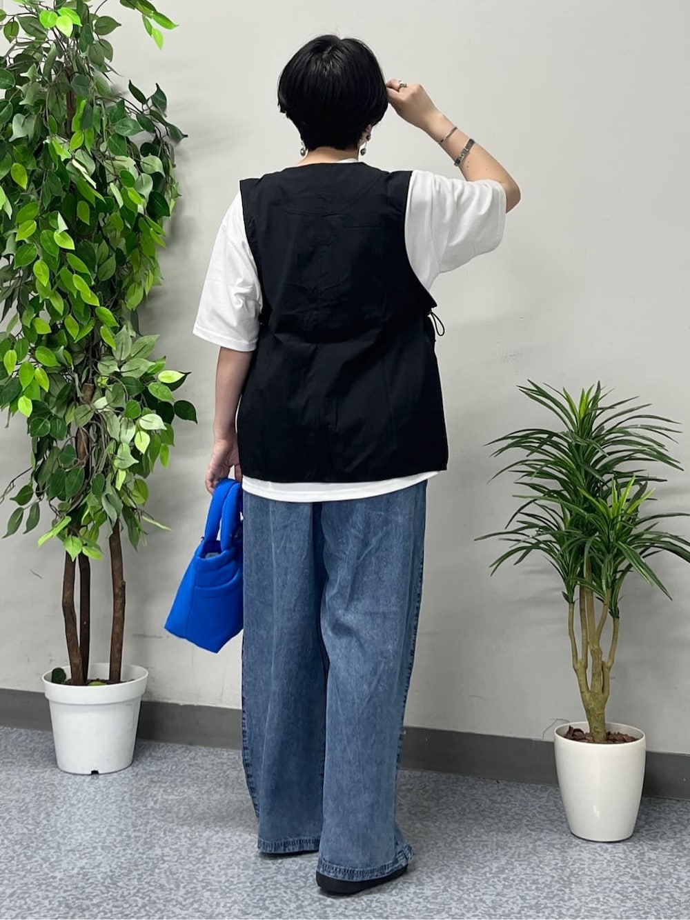 ホワイト系のTシャツ/カットソー、ブラック系のシャツ/ブラウス、ブルー系のデニムパンツを着用したレディースの春コーディネートの4枚目の写真