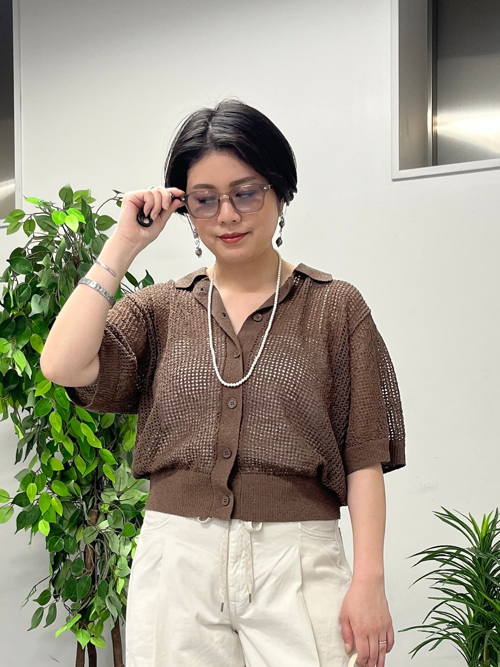 ブラウン系のニット/セーター、ホワイト系のその他パンツを着用したレディースの春コーディネートの7枚目の写真