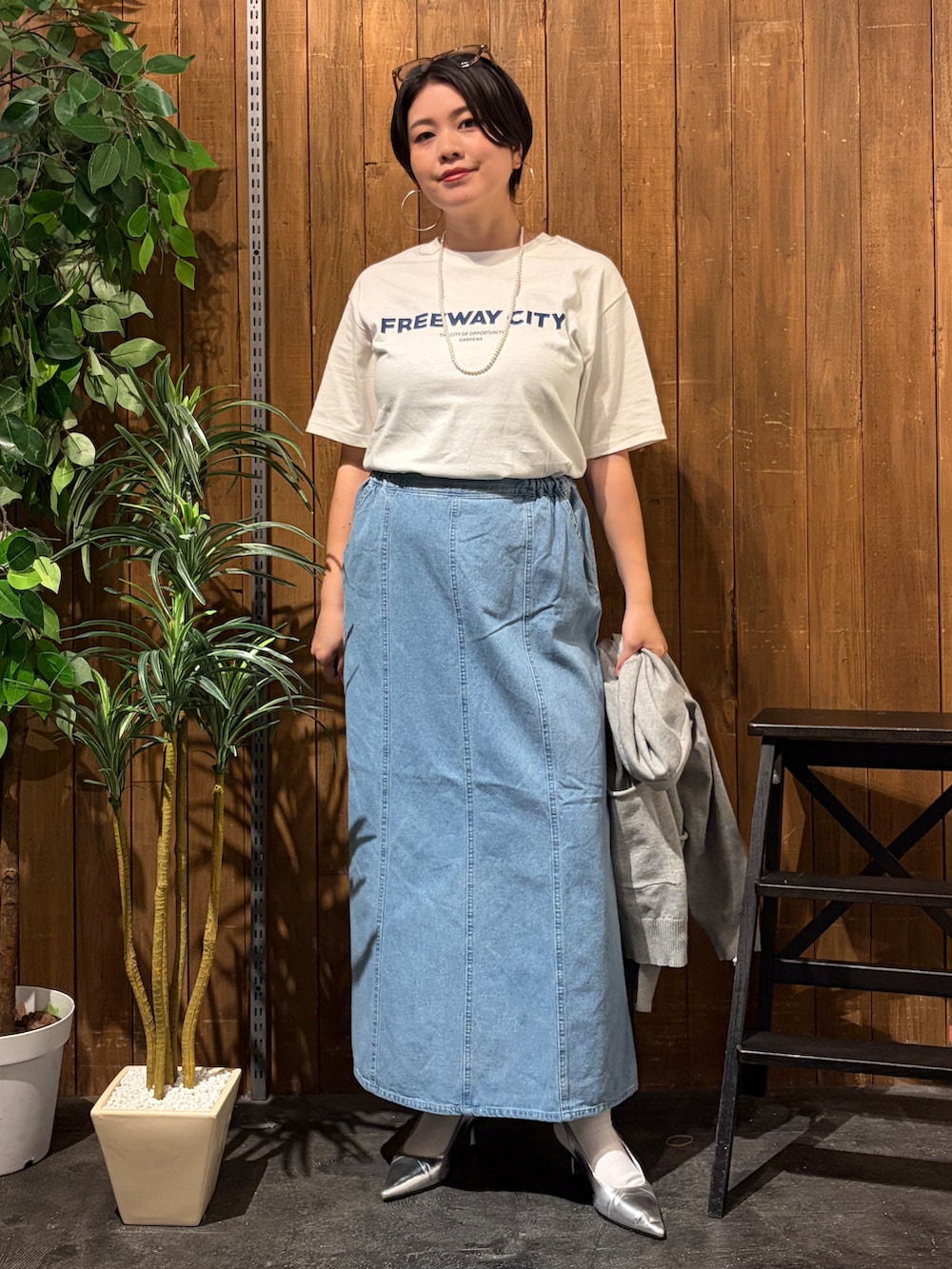 グレー系のニット/セーター、ブルー系のスカート、ホワイト系のTシャツ/カットソーを着用したレディースの秋コーディネートの5枚目の写真