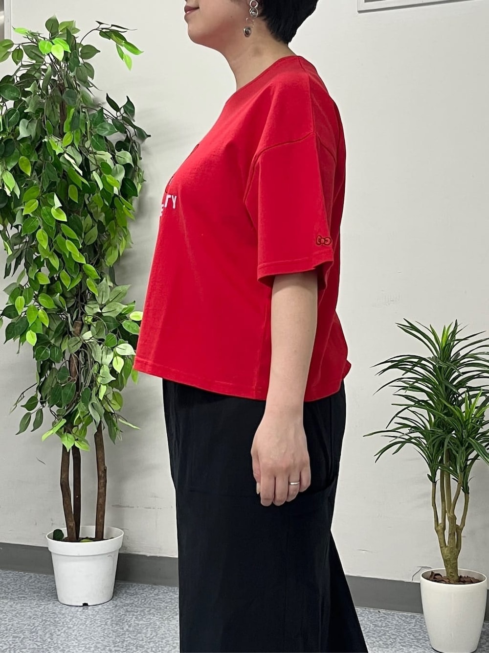 レッド系のTシャツ/カットソー、ブラック系のスカート、ブラック系のショルダーバッグを着用したレディースの春コーディネートの5枚目の写真
