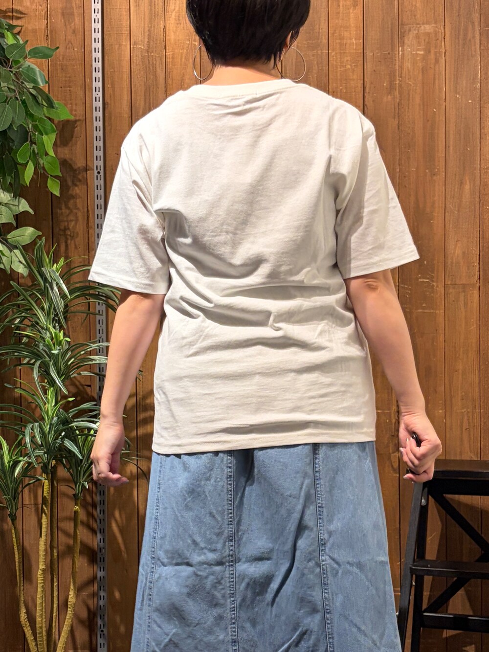 グレー系のニット/セーター、ブルー系のスカート、ホワイト系のTシャツ/カットソーを着用したレディースの秋コーディネートの7枚目の写真