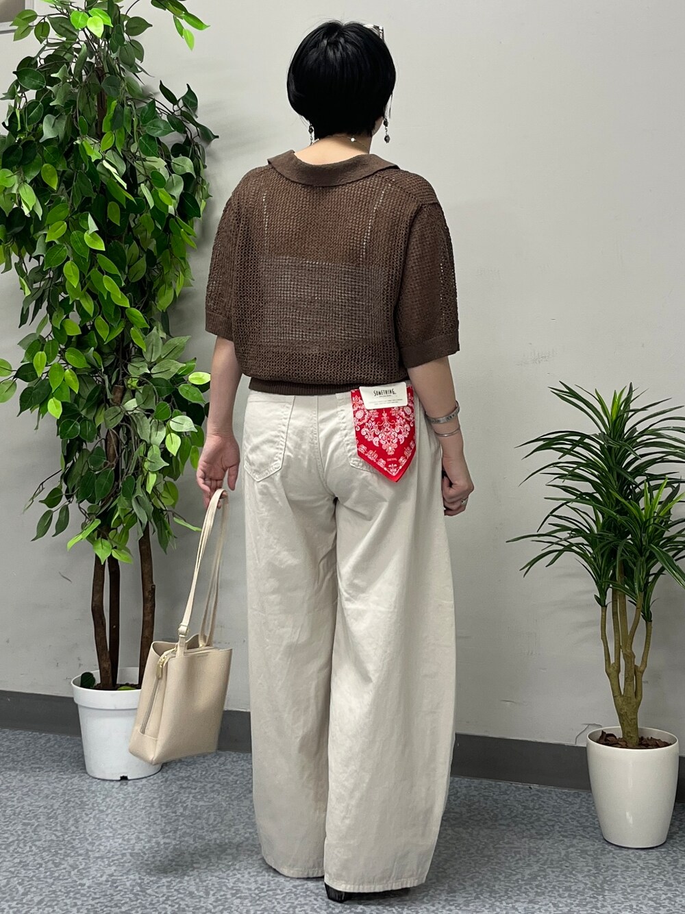 ブラウン系のニット/セーター、ホワイト系のその他パンツを着用したレディースの春コーディネートの3枚目の写真