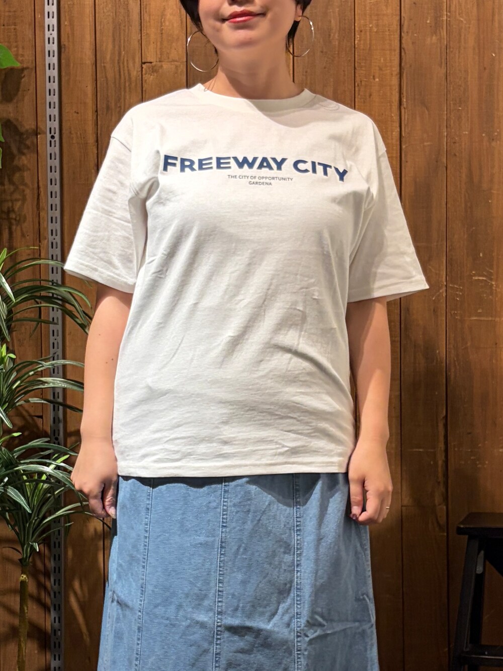グレー系のニット/セーター、ブルー系のスカート、ホワイト系のTシャツ/カットソーを着用したレディースの秋コーディネートの6枚目の写真