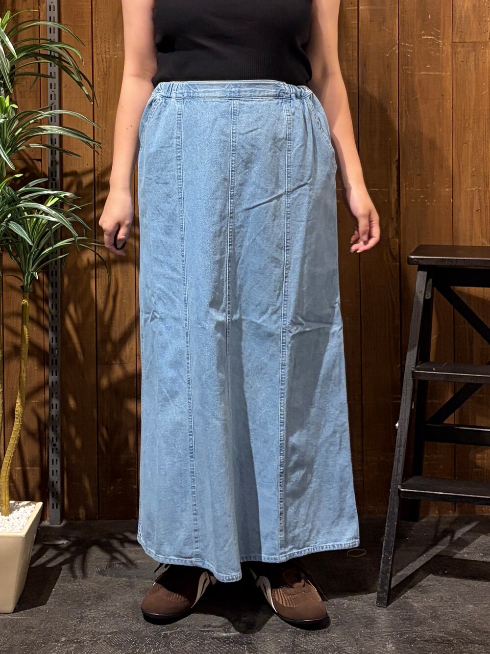 グレー系のニット/セーター、ブルー系のスカート、ホワイト系のTシャツ/カットソーを着用したレディースの秋コーディネートの9枚目の写真