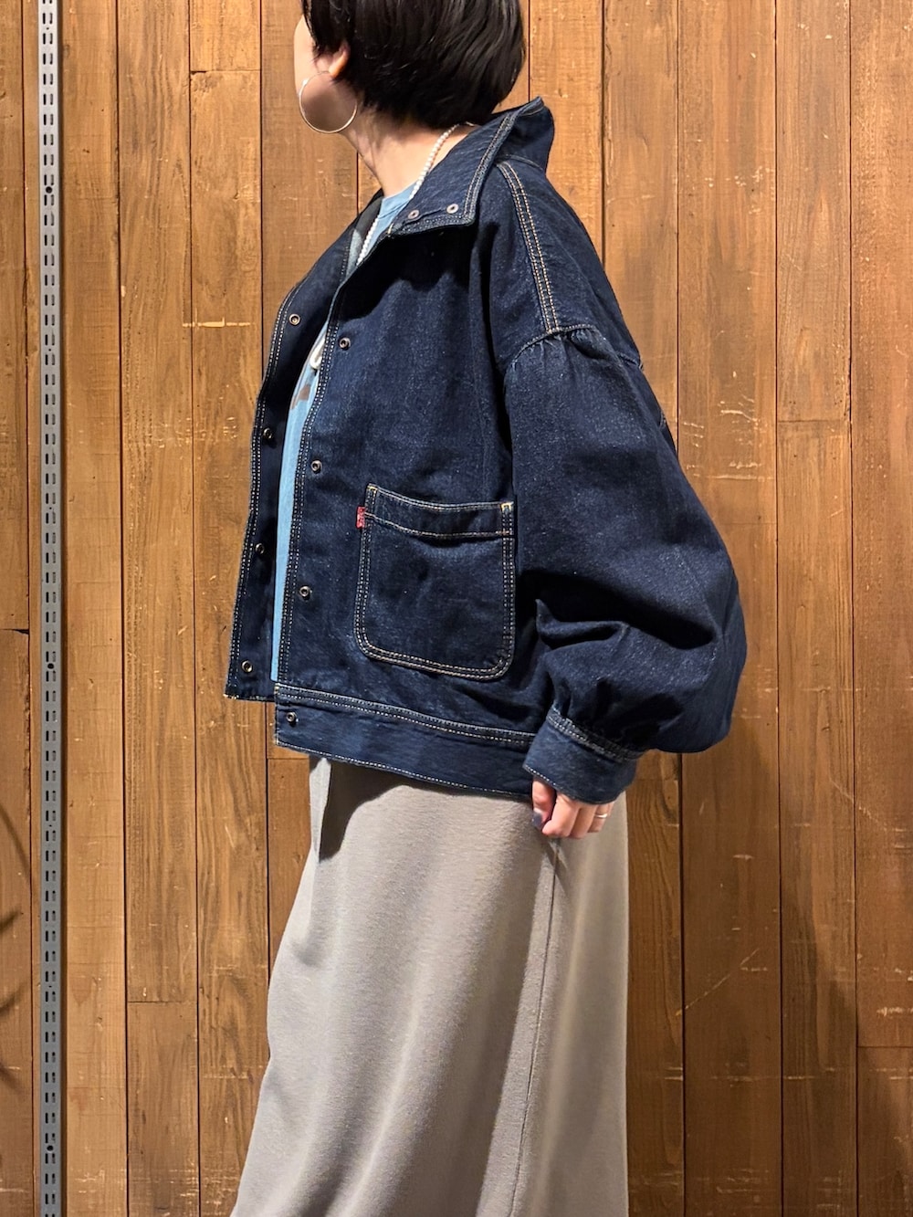 ブルー系のTシャツ/カットソー、ブラウン系のスカート、ブルー系のブルゾンを着用したレディースの秋コーディネートの7枚目の写真