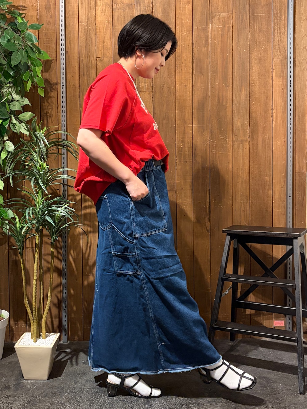レッド系のTシャツ/カットソー、ブルー系のスカート、ブラック系のトートバッグを着用したレディースの夏コーディネートの3枚目の写真