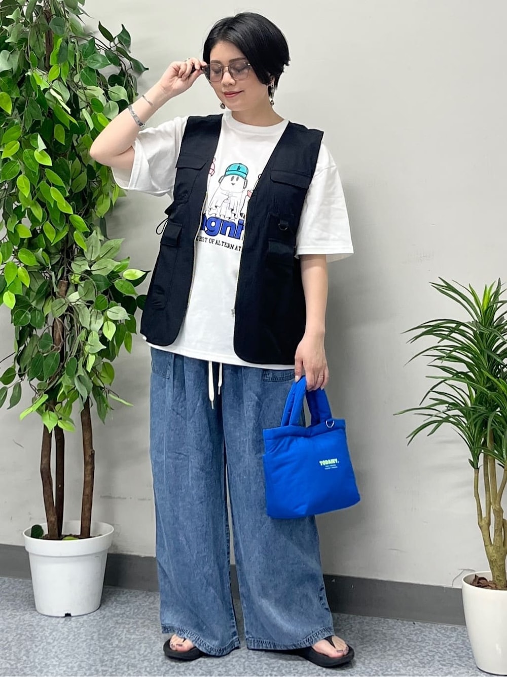 ホワイト系のTシャツ/カットソー、ブラック系のシャツ/ブラウス、ブルー系のデニムパンツを着用したレディースの春コーディネートの2枚目の写真