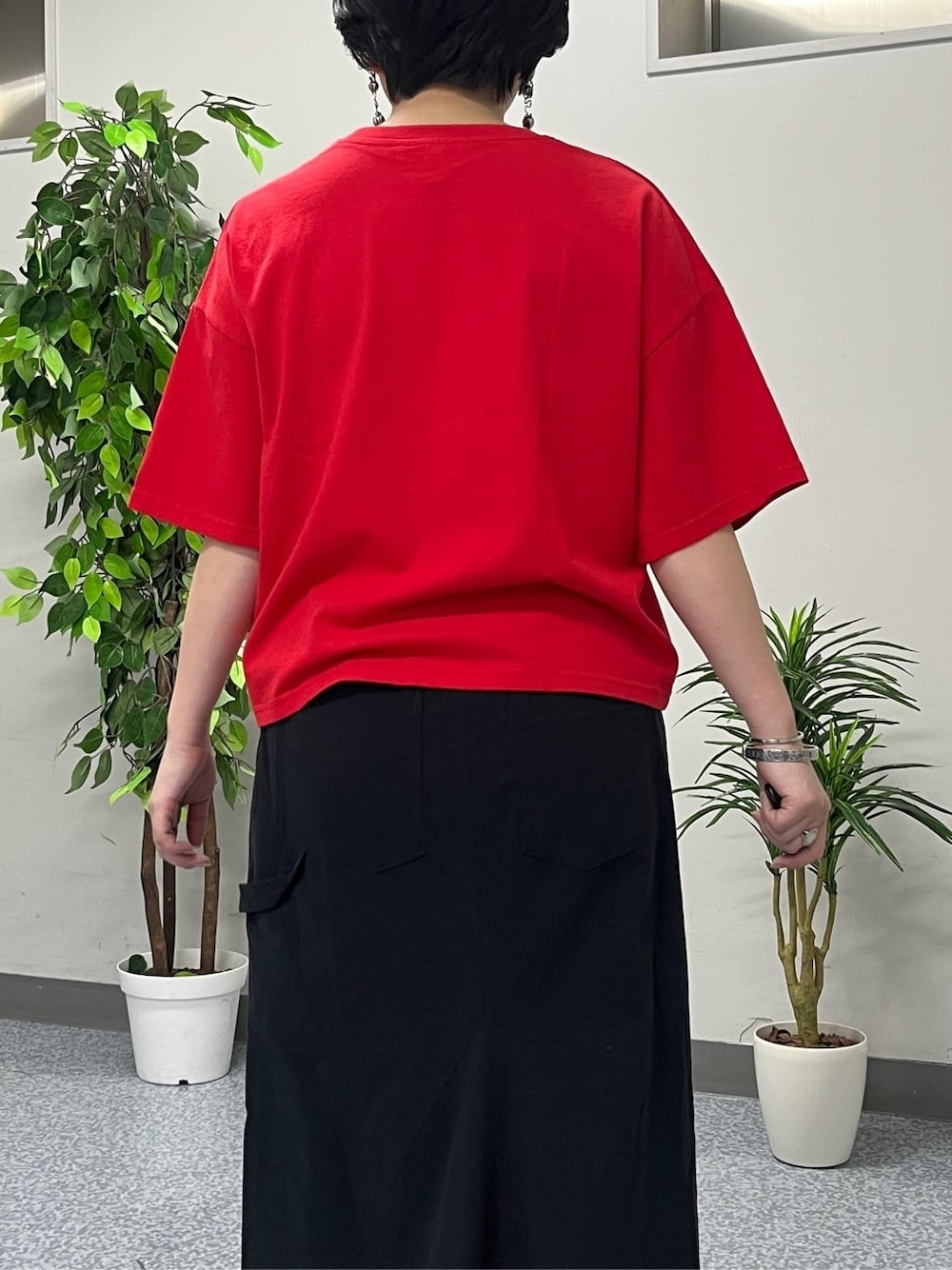 レッド系のTシャツ/カットソー、ブラック系のスカート、ブラック系のショルダーバッグを着用したレディースの春コーディネートの6枚目の写真