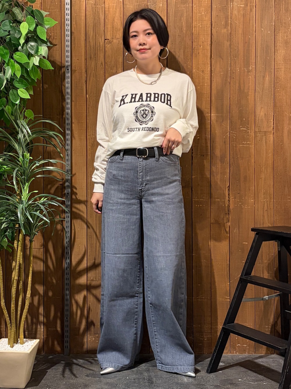 ブラック系のデニムパンツ、ホワイト系のTシャツ/カットソー、ブラック系のベストを着用したレディースの秋コーディネートの9枚目の写真