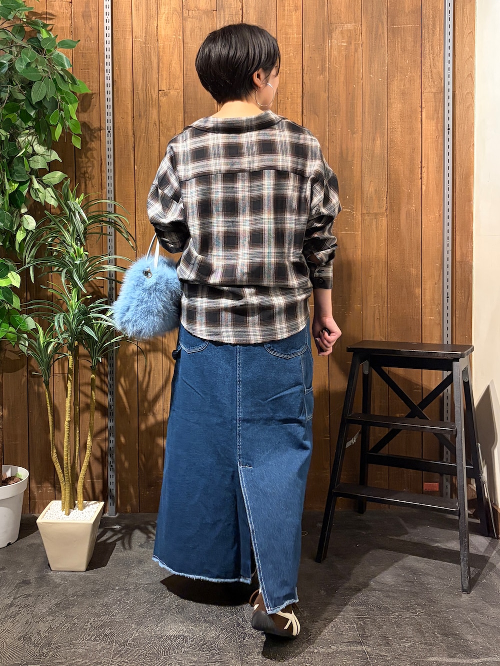 ブラック系のシャツ/ブラウス、ブルー系のスカート、ブラウン系のスニーカーを着用したレディースの秋コーディネートの3枚目の写真
