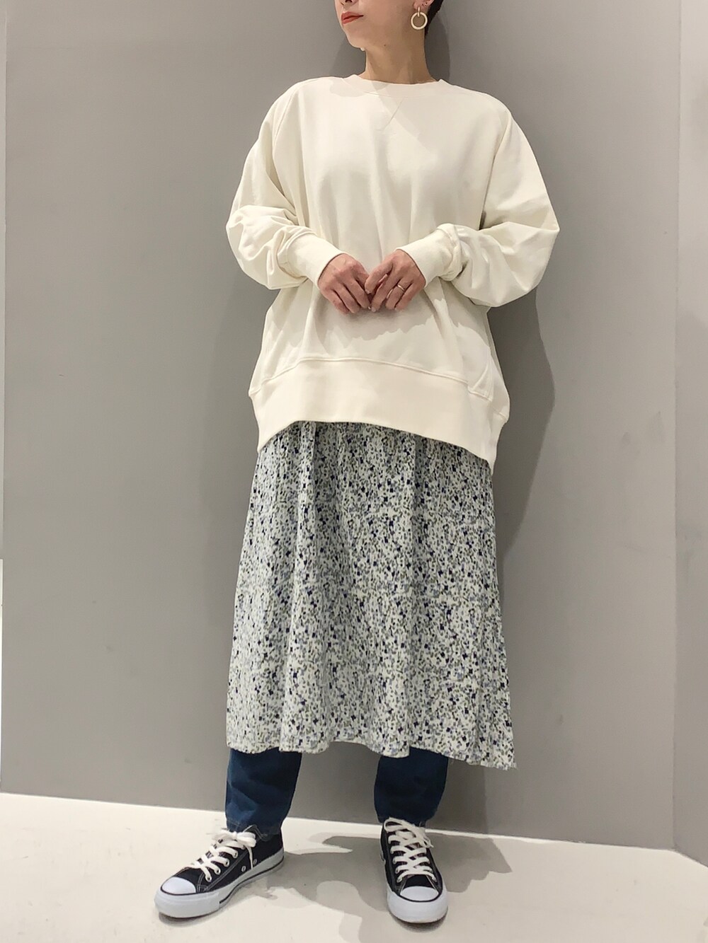 ホワイト系のスウェット、ブルー系のワンピースを着用したレディースの春コーディネートの2枚目の写真