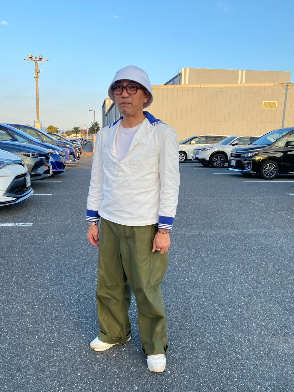 ホワイト系のシャツ/ブラウス、グリーン系のカーゴパンツ、ホワイト系のスニーカーを着用したメンズの秋コーディネートの2枚目の写真