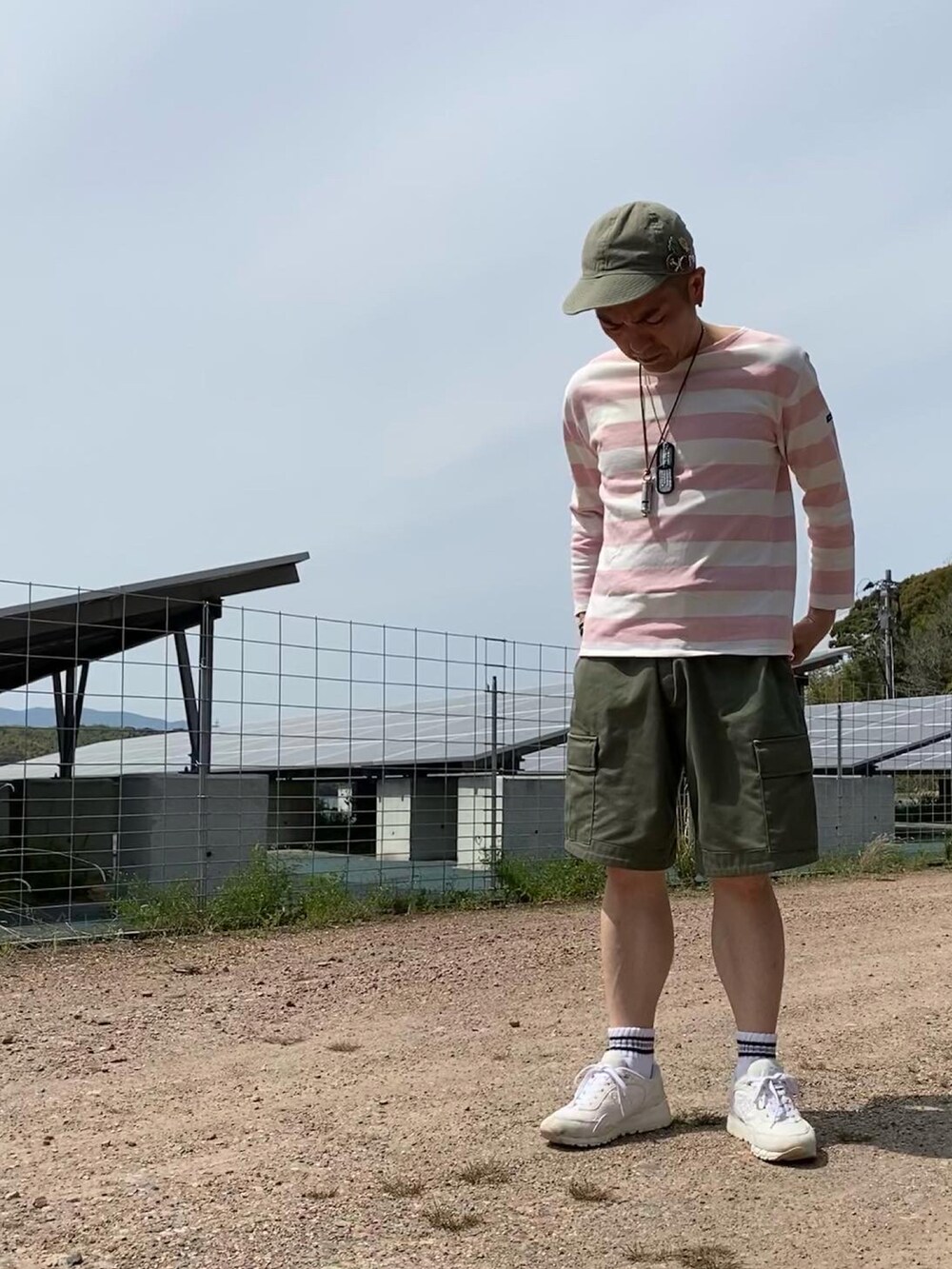 レッド系のスウェット、ピンク系のTシャツ/カットソー、グリーン系のカーゴパンツを着用したメンズの春コーディネートの2枚目の写真