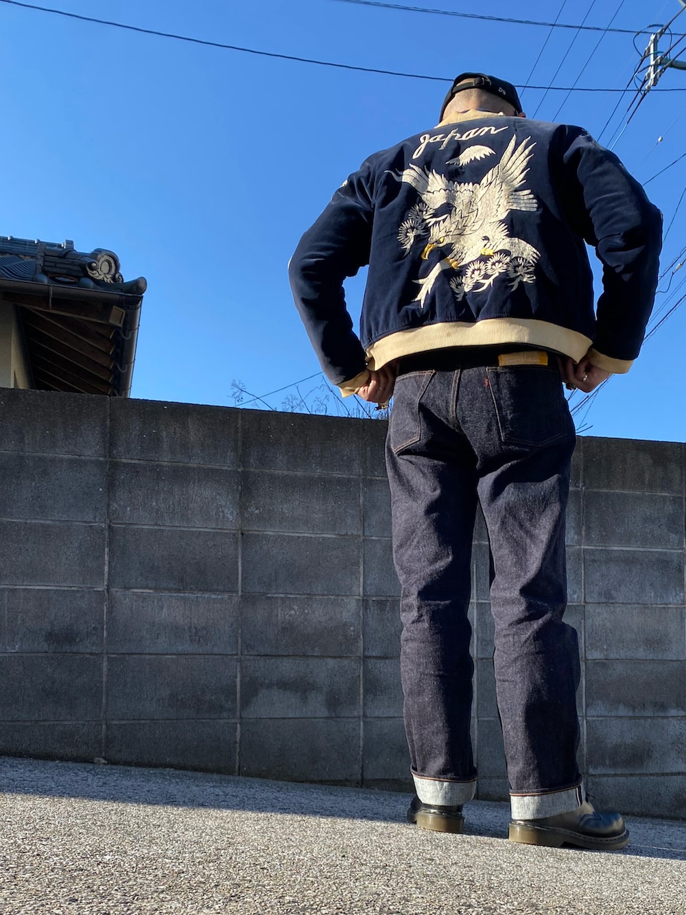 ブルー系のデニムパンツ、ブラック系のスカジャン、ブルー系のデニムジャケットを着用したメンズの冬コーディネートの2枚目の写真