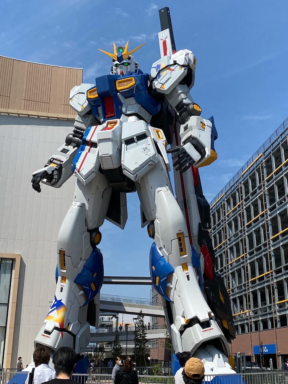 グリーン系のミリタリージャケット、パープル系のスウェット、ベージュ系のチノパンツを着用したメンズの春コーディネートの2枚目の写真