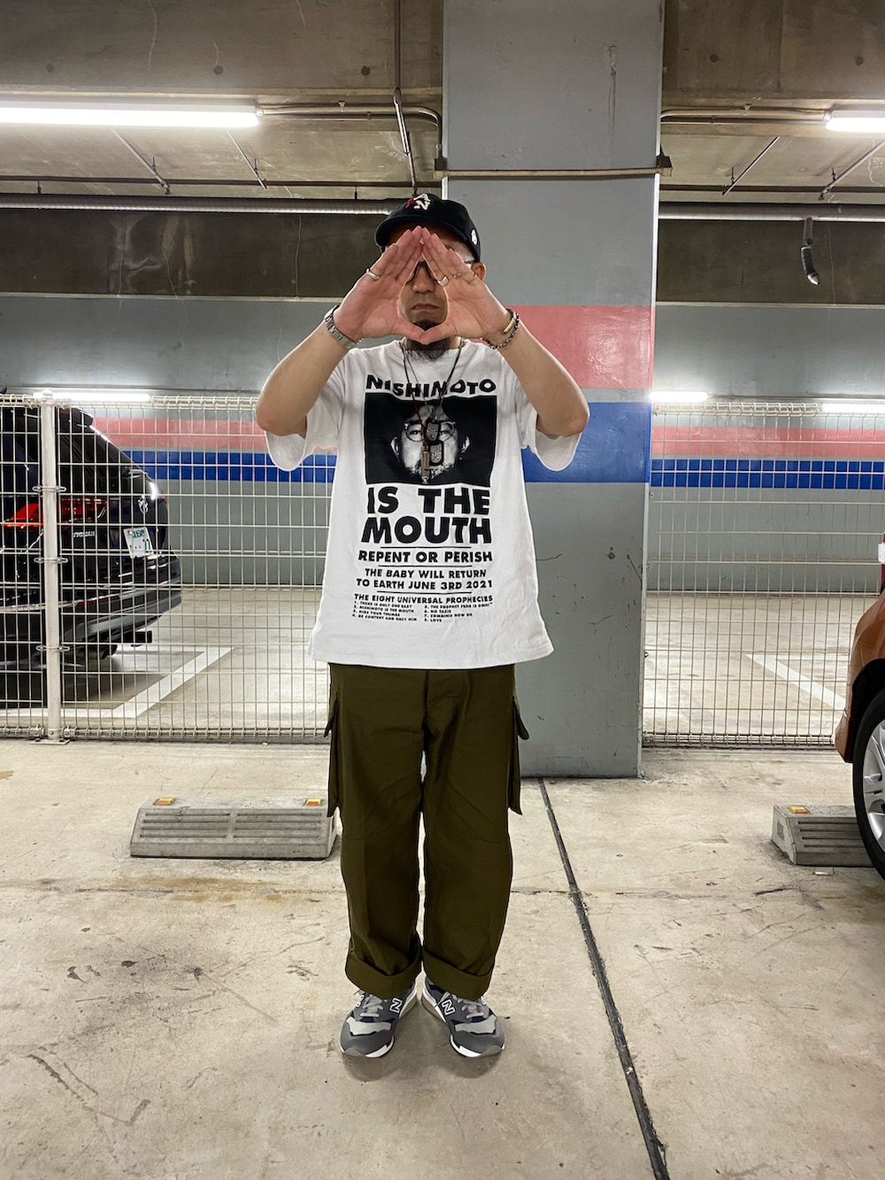 ホワイト系のTシャツ/カットソー、グリーン系のカーゴパンツ、グレー系のスニーカーを着用したメンズの春コーディネートの2枚目の写真