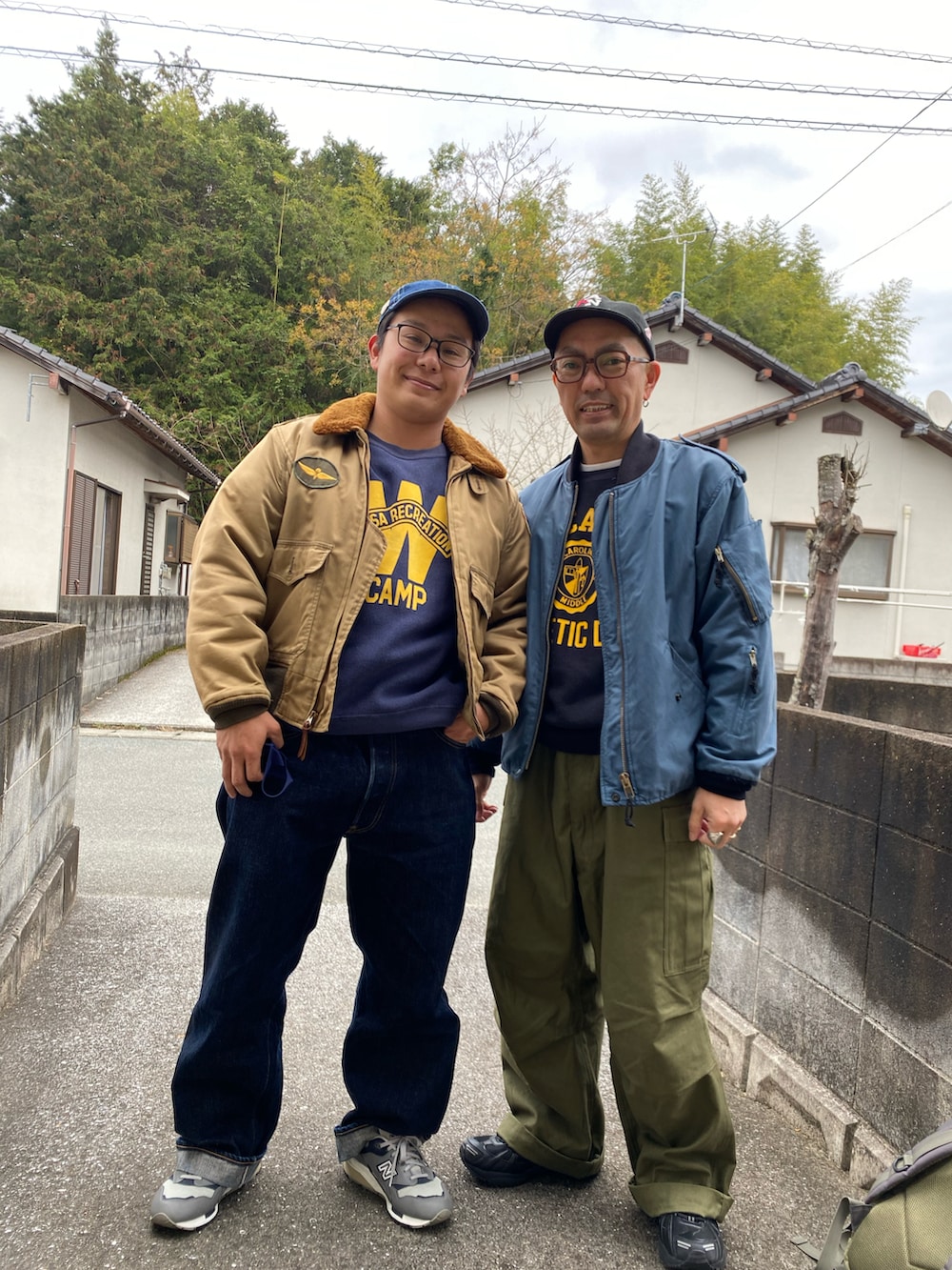 ブルー系のミリタリージャケット、ブラック系のスウェット、グリーン系のカーゴパンツを着用したメンズの冬コーディネートの2枚目の写真