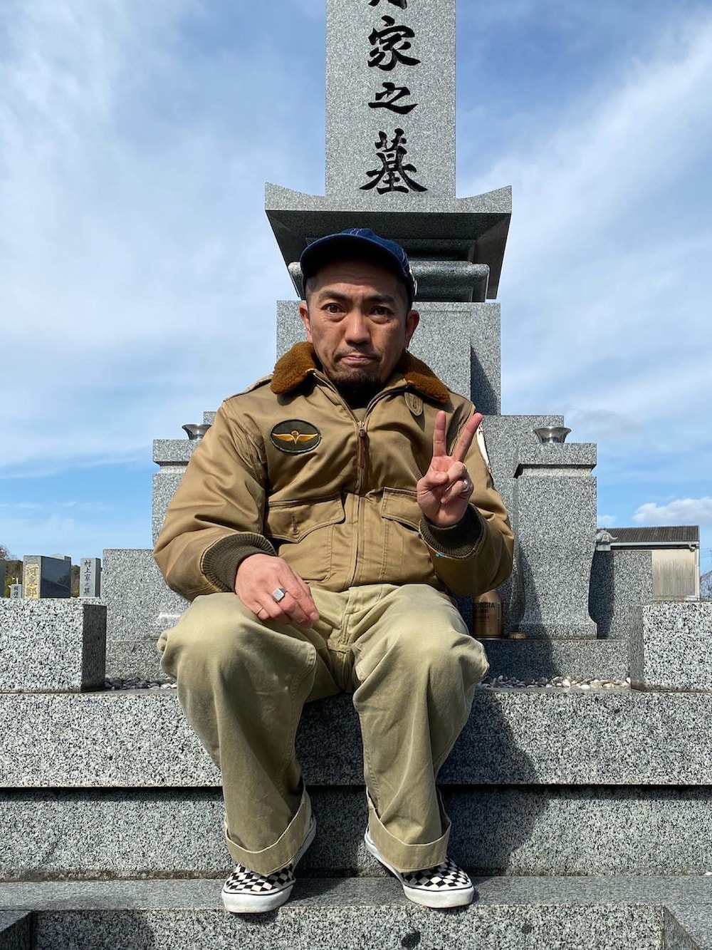 ベージュ系のチノパンツ、グリーン系のミリタリージャケット、グリーン系のスウェットを着用したメンズの冬コーディネートの2枚目の写真