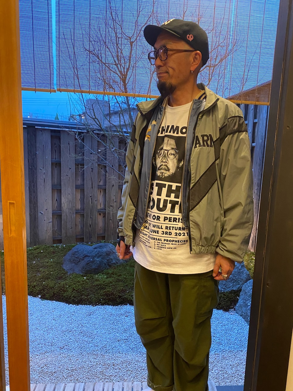 グレー系のミリタリージャケット、ブルー系のその他アウター、ホワイト系のTシャツ/カットソーを着用したメンズの春コーディネートの2枚目の写真