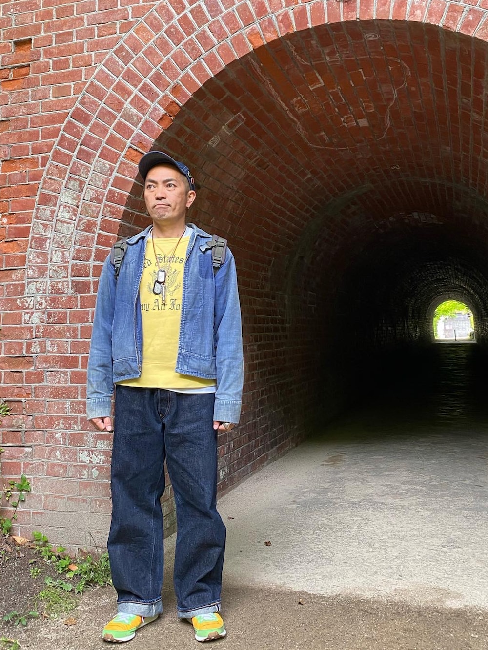 ブルー系のブルゾン、イエロー系のスウェット、ブルー系のデニムパンツを着用したメンズの春コーディネートの2枚目の写真