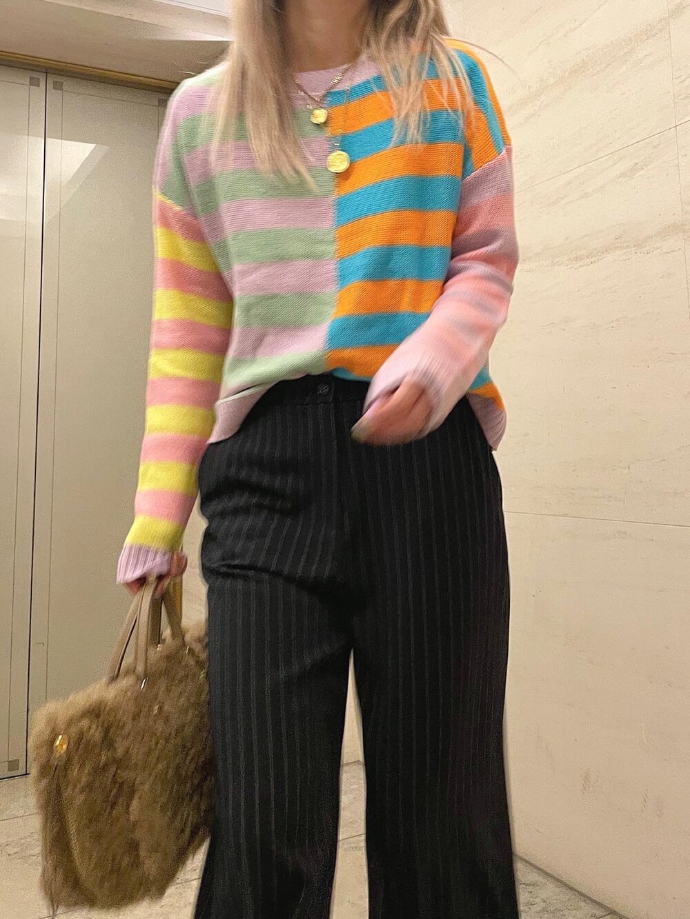 ブルー系のパンツ、その他のスニーカー、ブラウン系のハンドバッグを着用したレディースの秋コーディネートの2枚目の写真