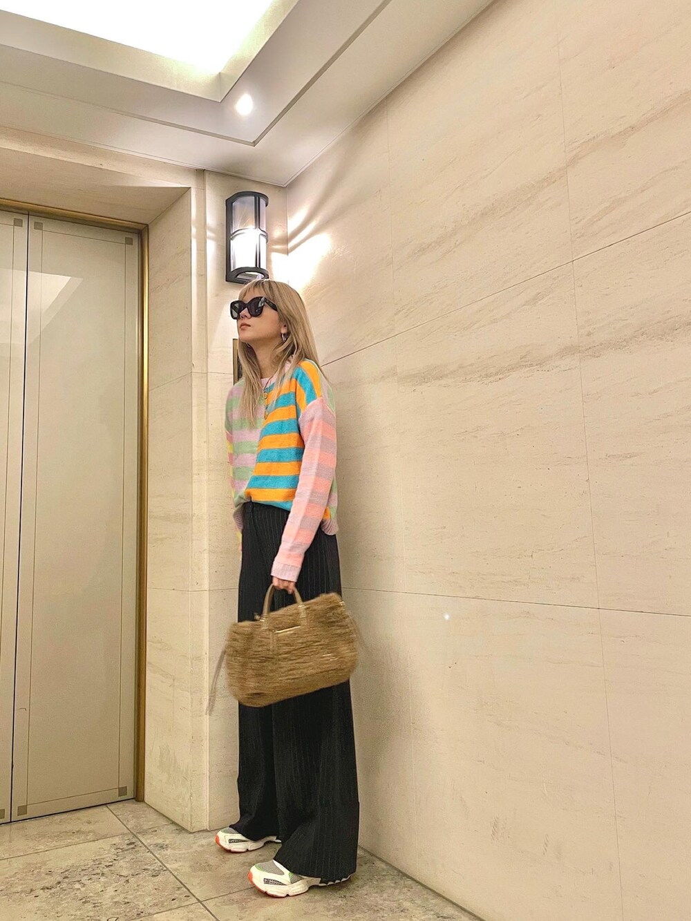 ブルー系のパンツ、その他のスニーカー、ブラウン系のハンドバッグを着用したレディースの秋コーディネートの5枚目の写真