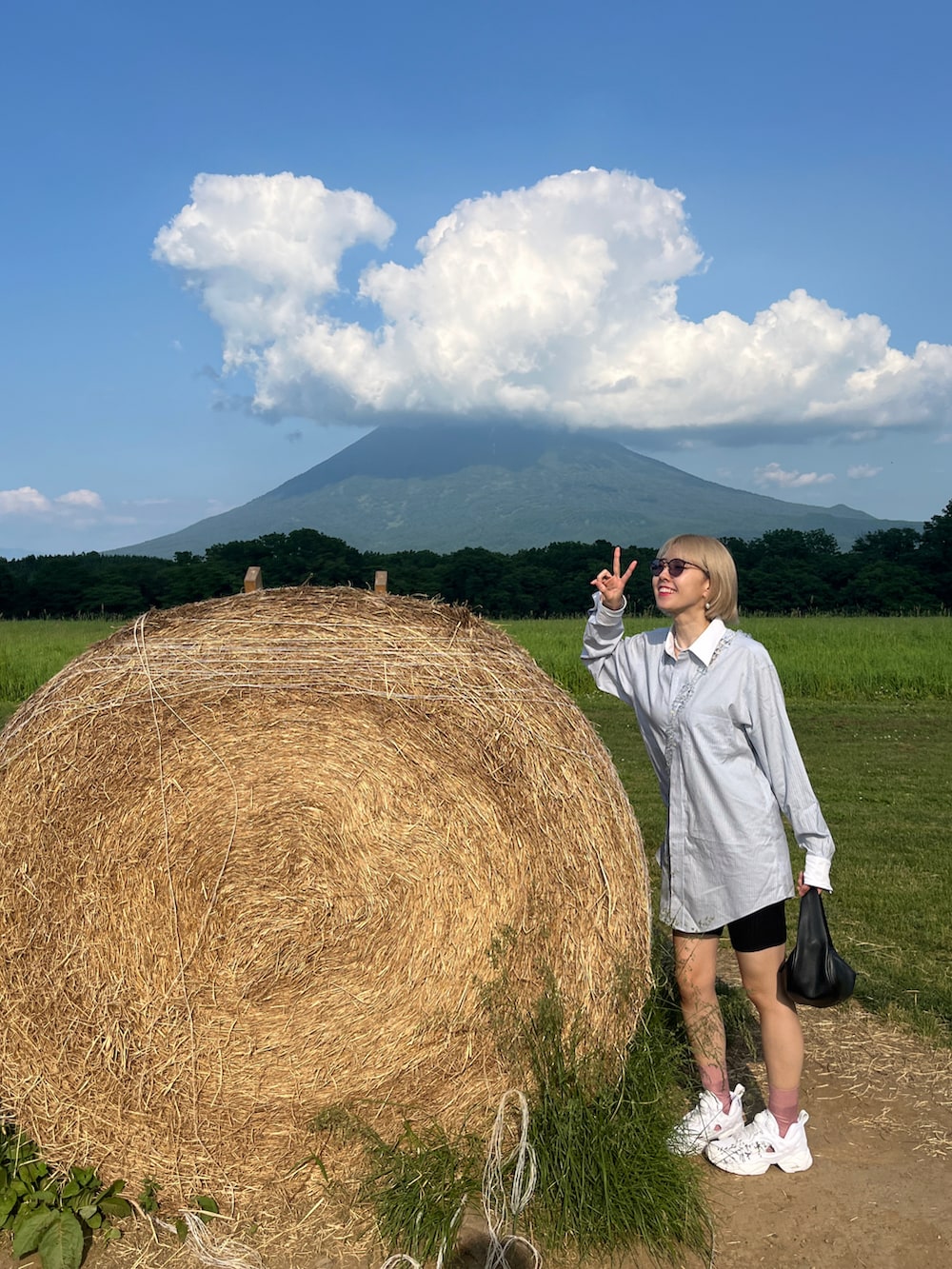 ブルー系のシャツ/ブラウス、ホワイト系のスニーカー、ブラック系のレギンス/スパッツを着用したレディースの夏コーディネートの3枚目の写真