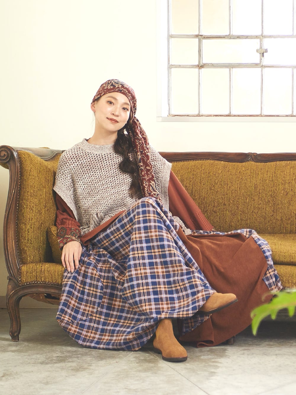 ベージュ系のニット/セーター、ブラウン系のTシャツ/カットソー、ブルー系のスカートを着用したレディースの秋コーディネートの3枚目の写真