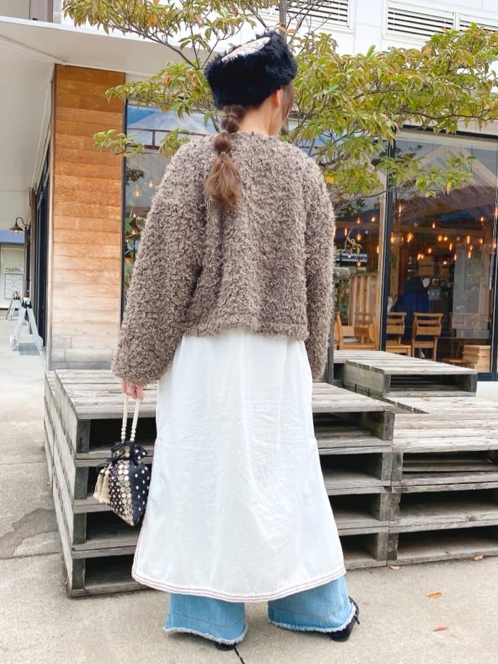 ブラウン系のその他アウター、ホワイト系のワンピース、ブラック系のハンドバッグを着用したレディースの秋コーディネートの4枚目の写真