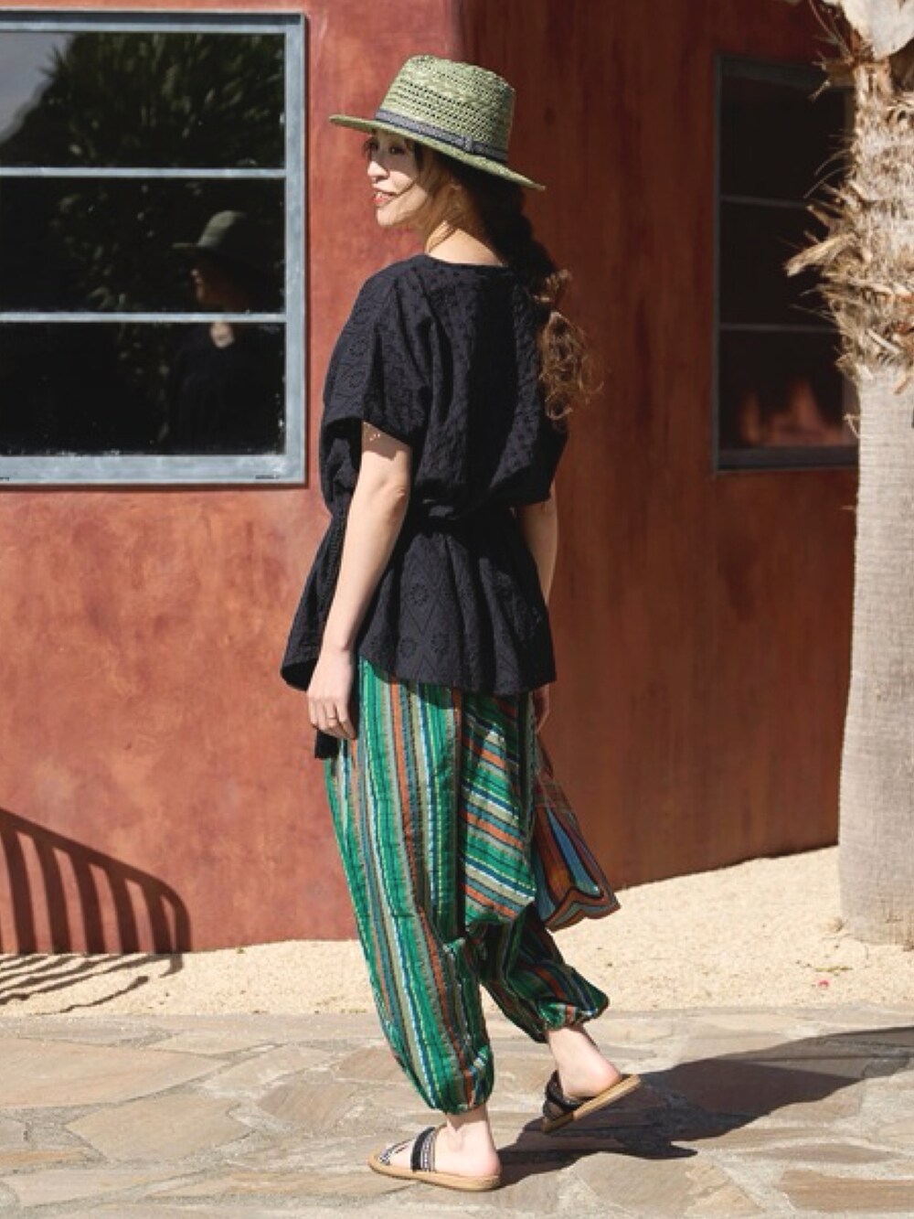 ブラック系のその他トップス、オレンジ系のトートバッグ、ブラック系のサンダルを着用したレディースの夏コーディネートの4枚目の写真