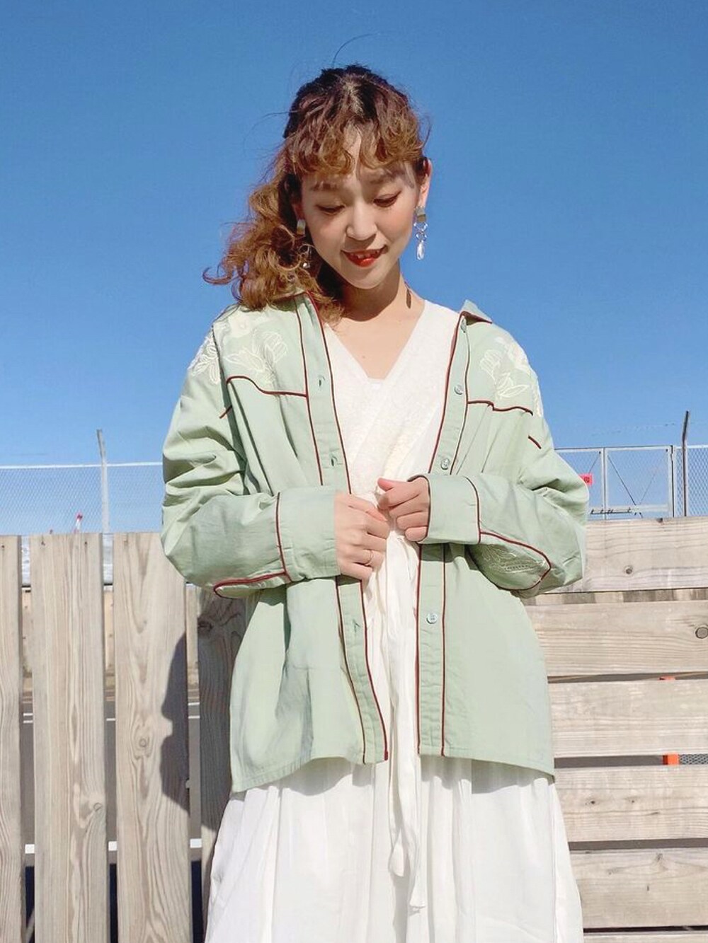 グリーン系のシャツ/ブラウス、ホワイト系のワンピースを着用したレディースの冬コーディネートの2枚目の写真