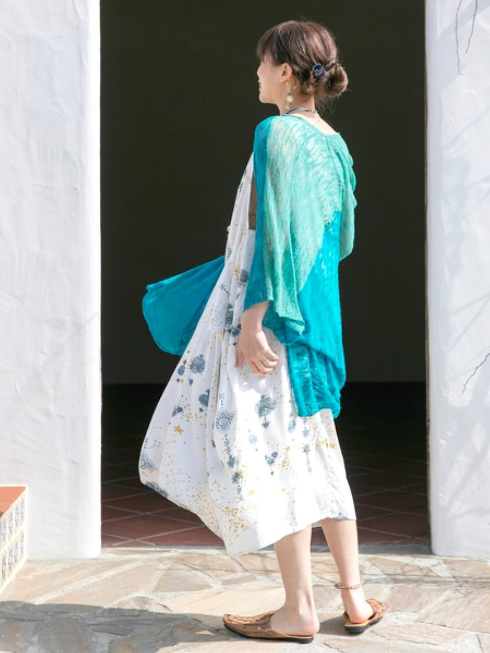 ホワイト系のワンピース、イエロー系のサンダル、ゴールド系のイヤーカフを着用したレディースの夏コーディネートの3枚目の写真