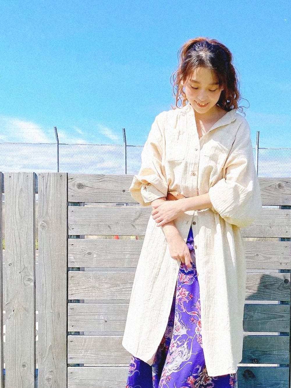 ホワイト系のシャツワンピース、パープル系のスカートを着用したレディースの秋コーディネートの2枚目の写真