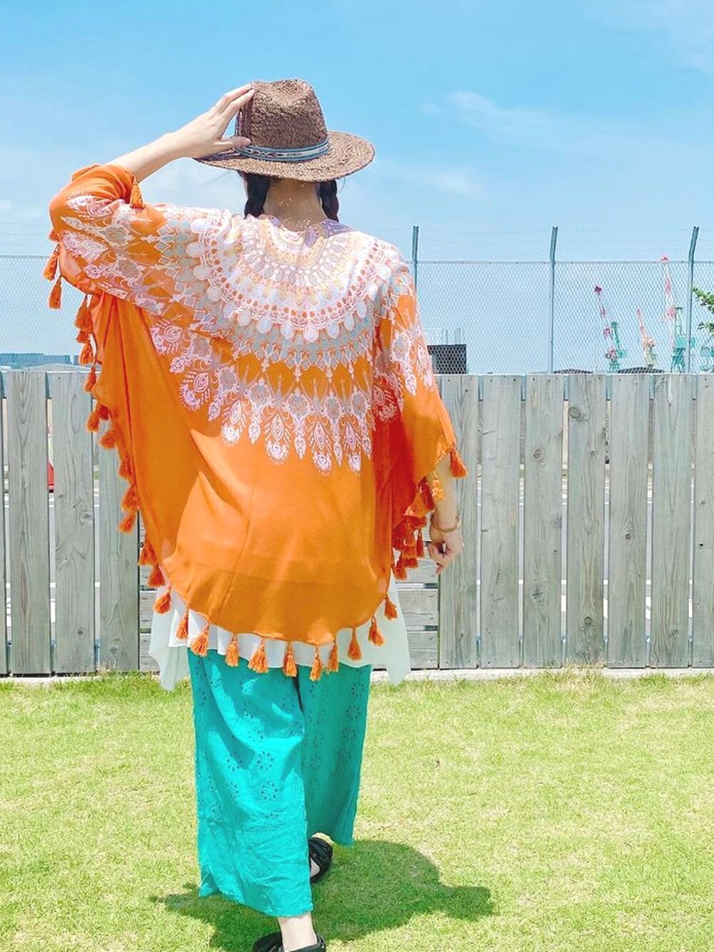 オレンジ系のカーディガン/ボレロ、ホワイト系のタンクトップ、ブルー系のその他パンツを着用したレディースの夏コーディネートの2枚目の写真