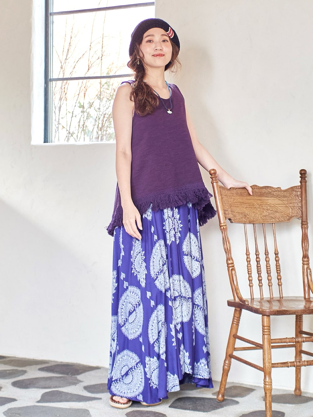 パープル系のスカート、パープル系のタンクトップ、ブラウン系のサンダルを着用したレディースの夏コーディネートの2枚目の写真
