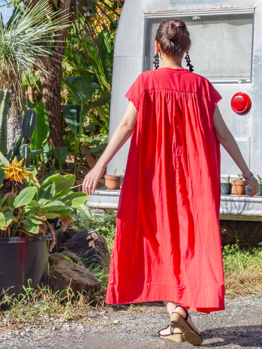 レッド系のワンピース、ブラック系のサンダル、ブラック系のピアス（両耳用）を着用したレディースの春コーディネートの5枚目の写真