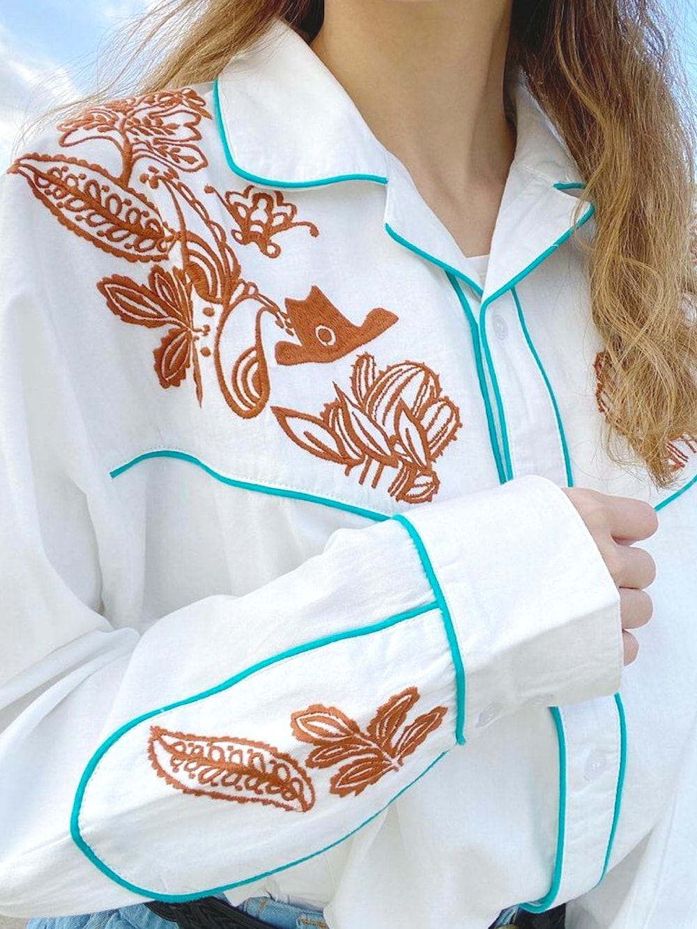 ホワイト系のシャツ/ブラウス、ブルー系のデニムパンツ、ブラウン系のブーツを着用したレディースの冬コーディネートの3枚目の写真