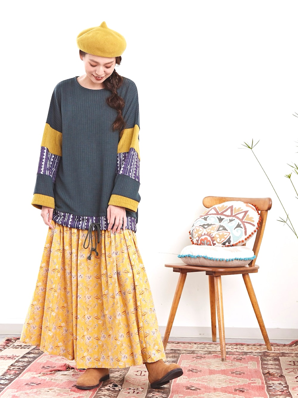 グリーン系のその他トップス、イエロー系のスカート、ベージュ系のブーツを着用したレディースの秋コーディネートの2枚目の写真