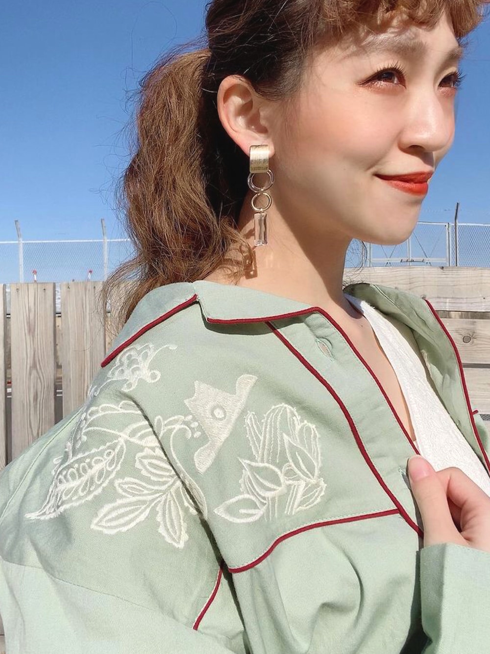 グリーン系のシャツ/ブラウス、ホワイト系のワンピースを着用したレディースの冬コーディネートの3枚目の写真