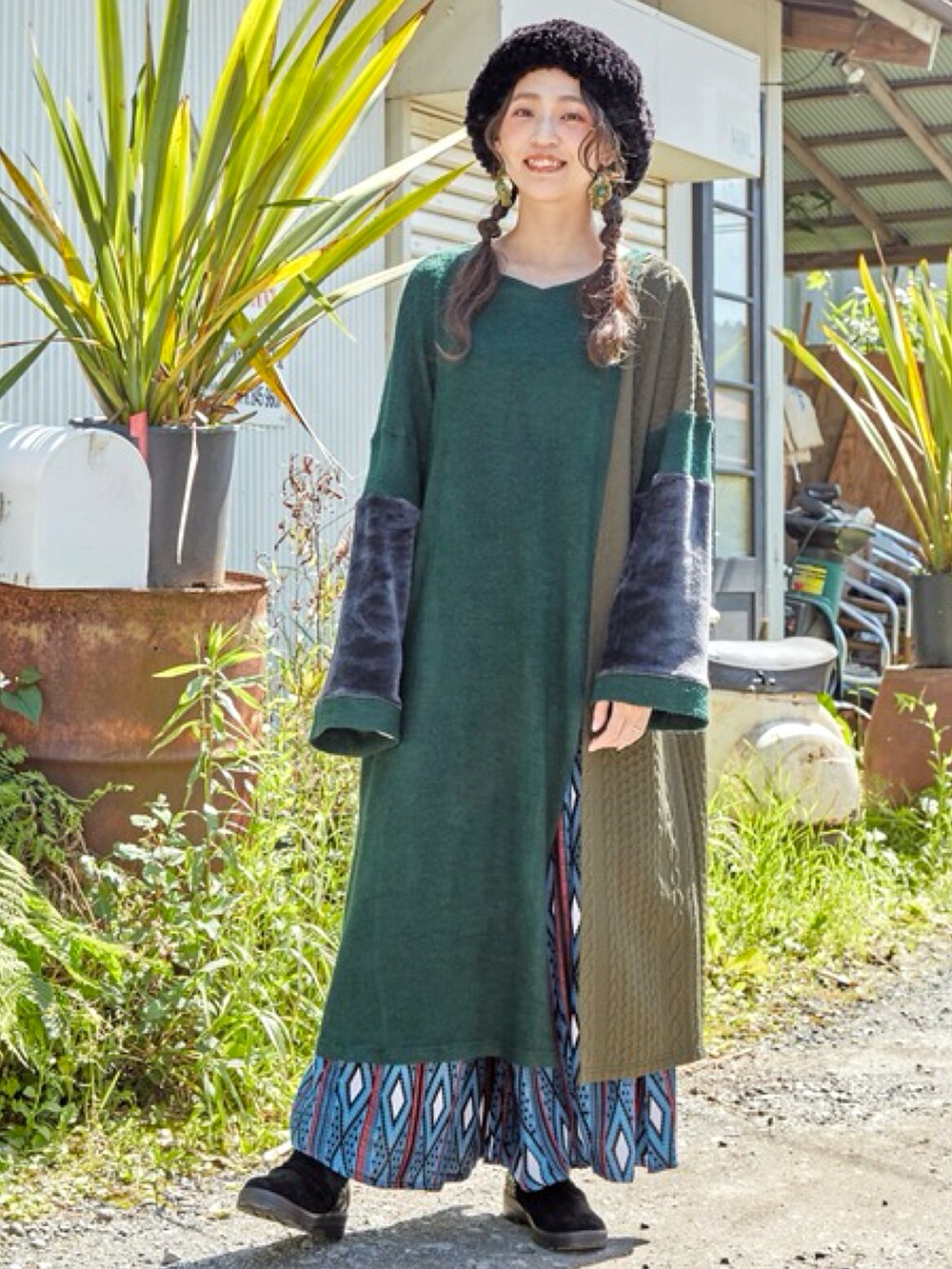 グリーン系のワンピース、ブルー系のその他パンツ、ブラック系のハンチング/ベレー帽を着用したレディースの秋コーディネートの2枚目の写真