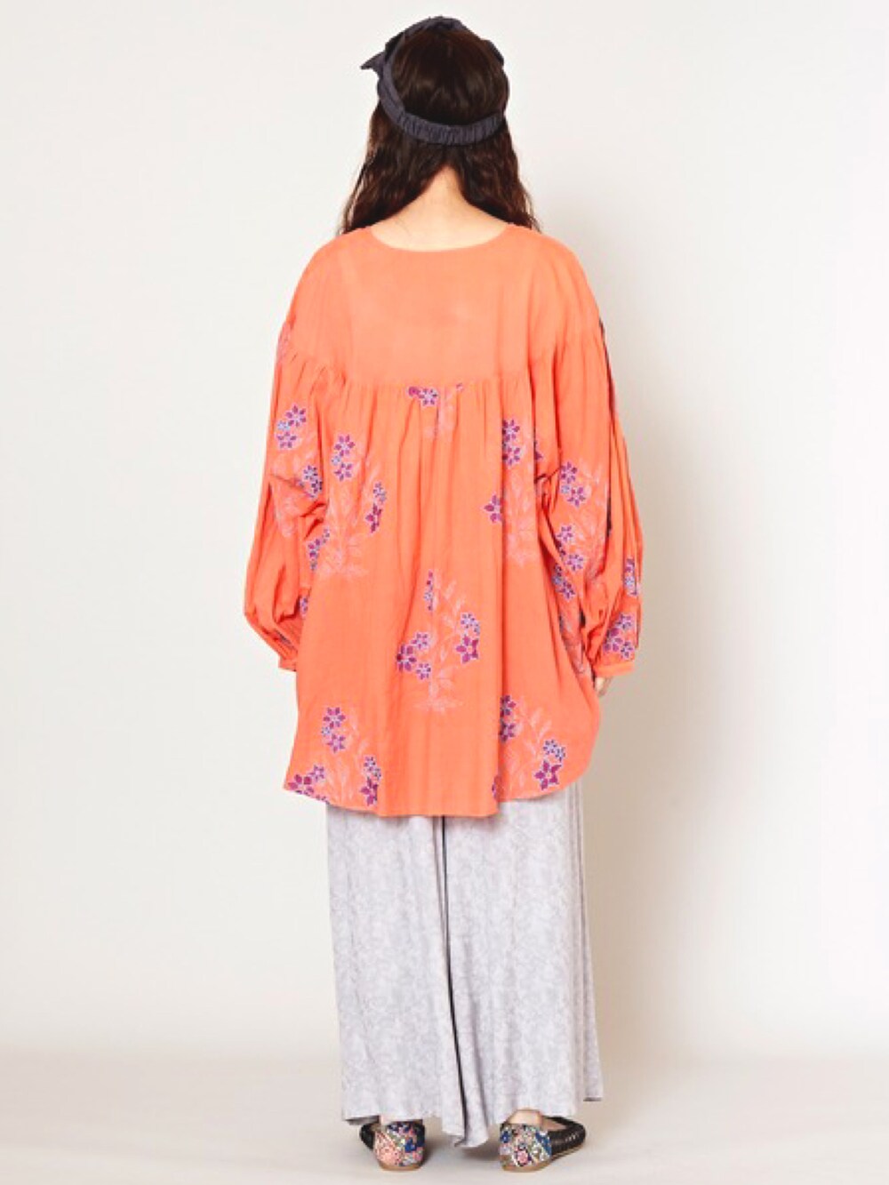 オレンジ系のその他トップス、グレー系のその他パンツ、ブラック系のパンプスを着用したレディースの春コーディネートの3枚目の写真