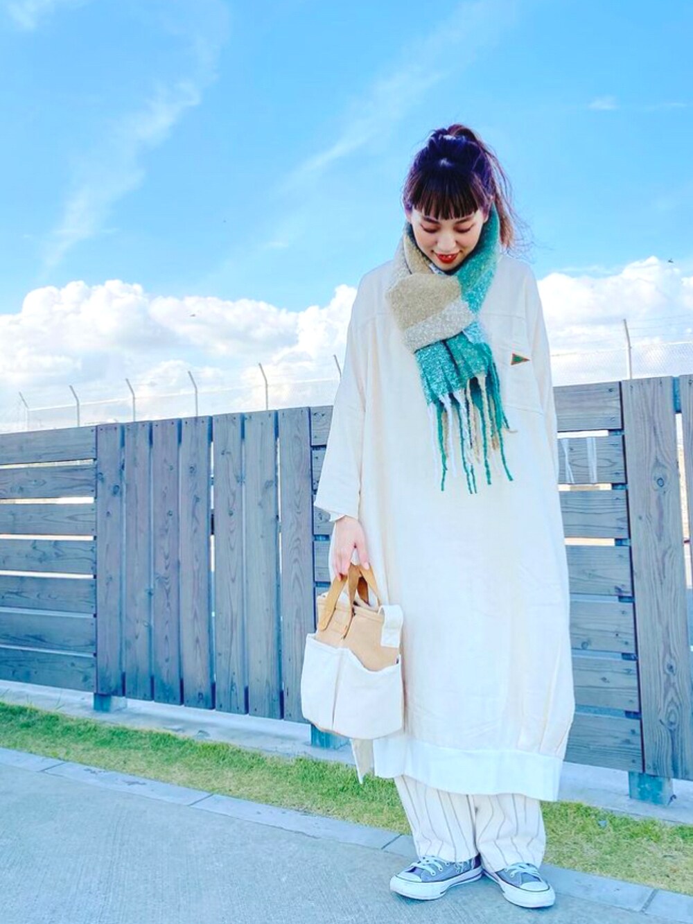 ホワイト系のワンピース、ベージュ系のショルダーバッグ、ホワイト系のTシャツ/カットソーを着用したレディースの冬コーディネートの2枚目の写真