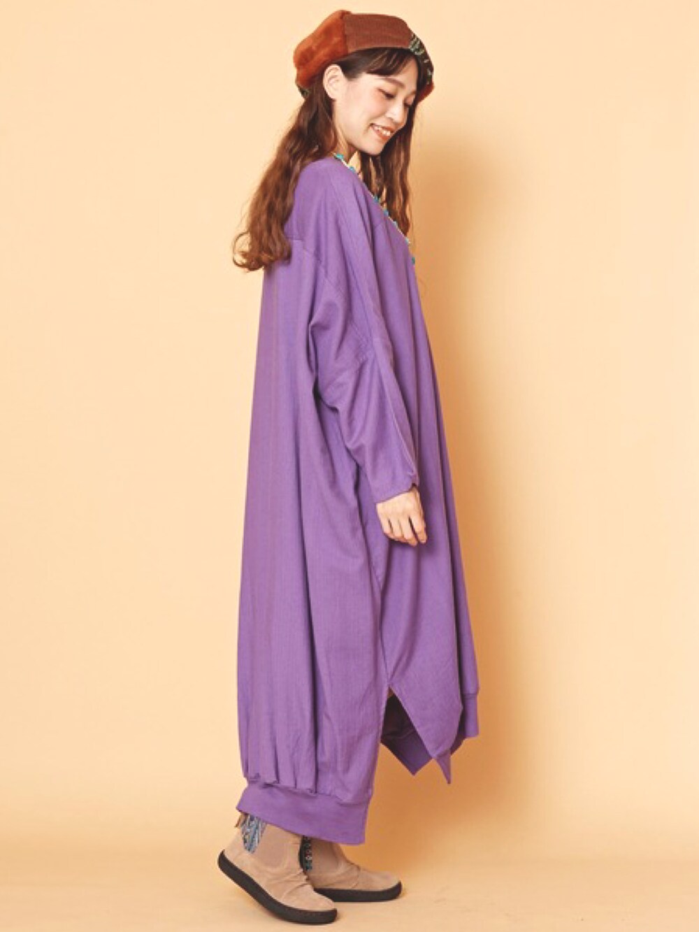 パープル系のワンピース、ブラウン系のハンチング/ベレー帽、ホワイト系のネックレスを着用したレディースの冬コーディネートの2枚目の写真