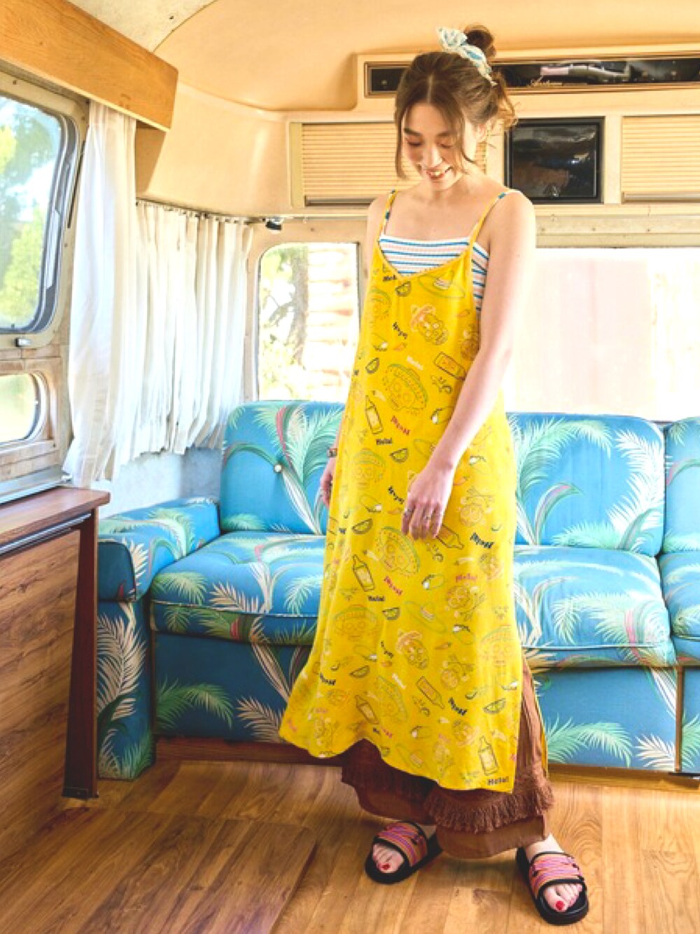 イエロー系のワンピース、ホワイト系のキャミソール、ブラウン系のその他パンツを着用したレディースの夏コーディネートの2枚目の写真