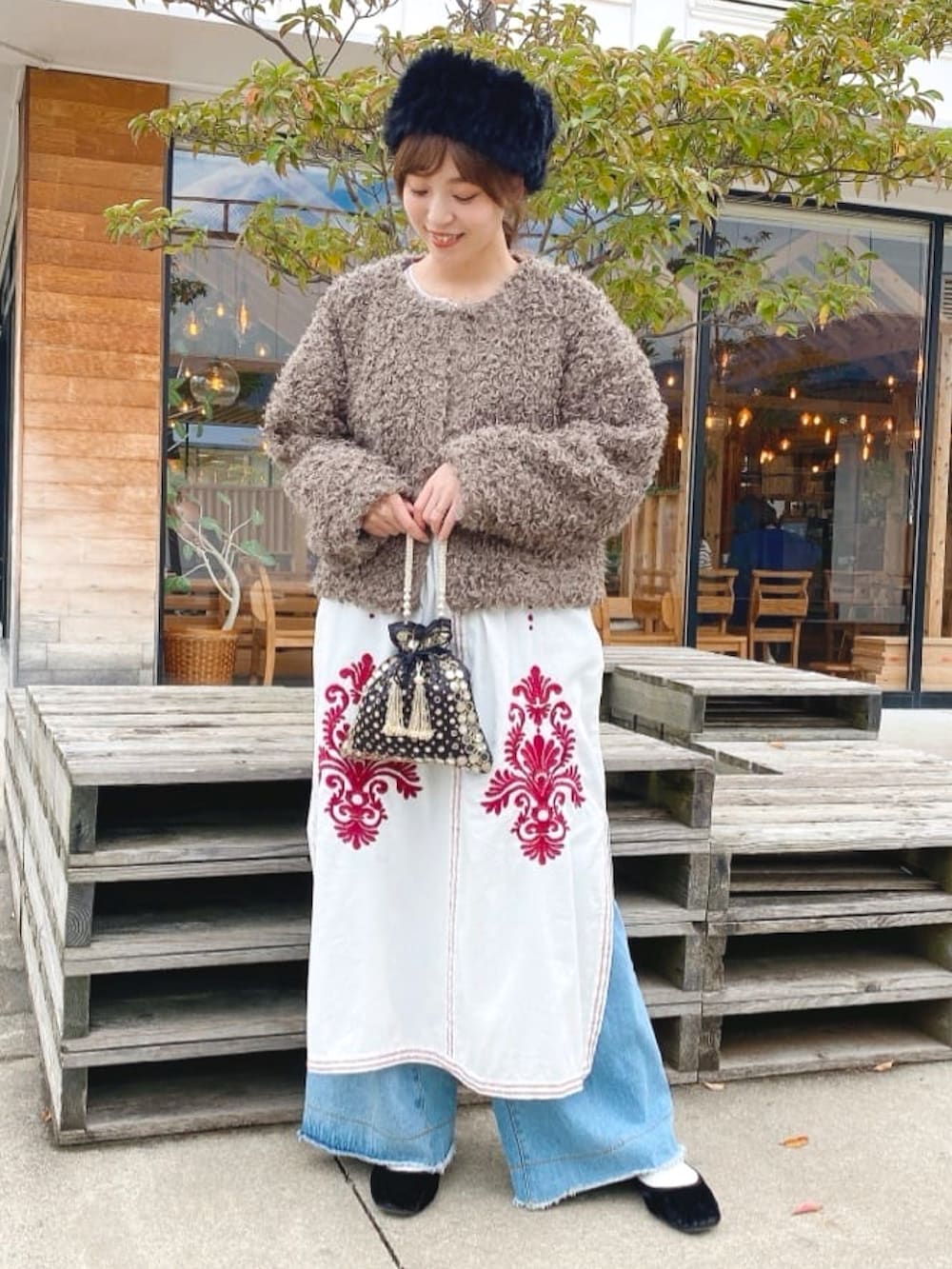 ブラウン系のその他アウター、ホワイト系のワンピース、ブラック系のハンドバッグを着用したレディースの秋コーディネートの3枚目の写真