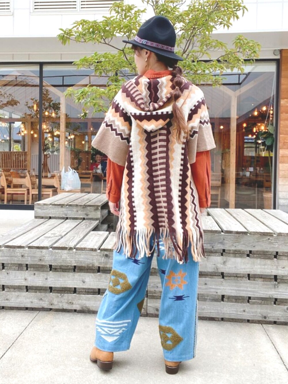 ベージュ系のニット/セーター、オレンジ系のシャツ/ブラウス、ブルー系のデニムパンツを着用したレディースの秋コーディネートの3枚目の写真