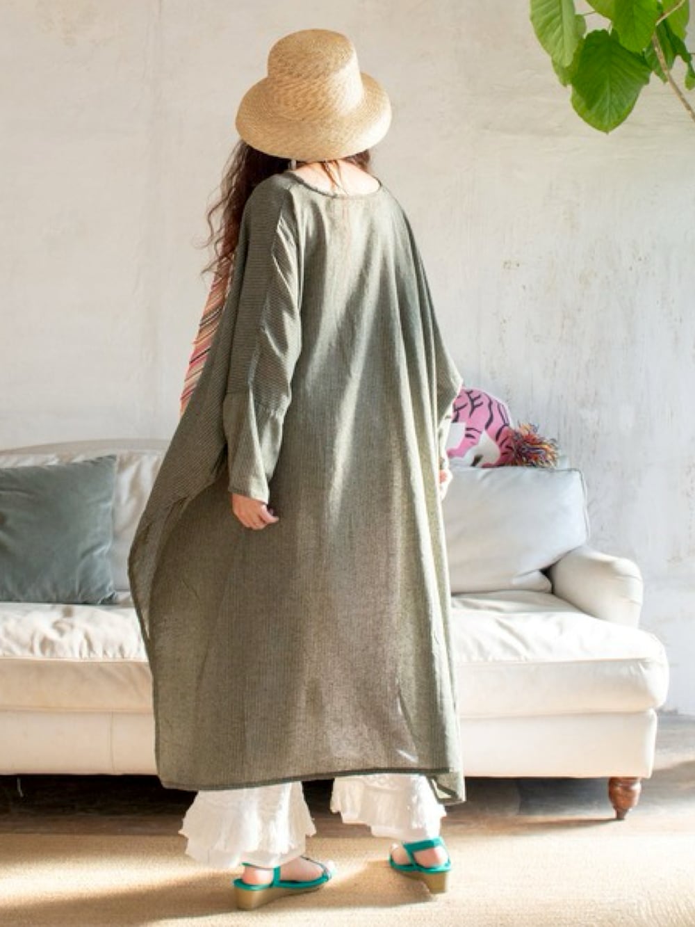 グリーン系のワンピース、ブルー系のサンダル、ベージュ系のハットを着用したレディースの春コーディネートの3枚目の写真